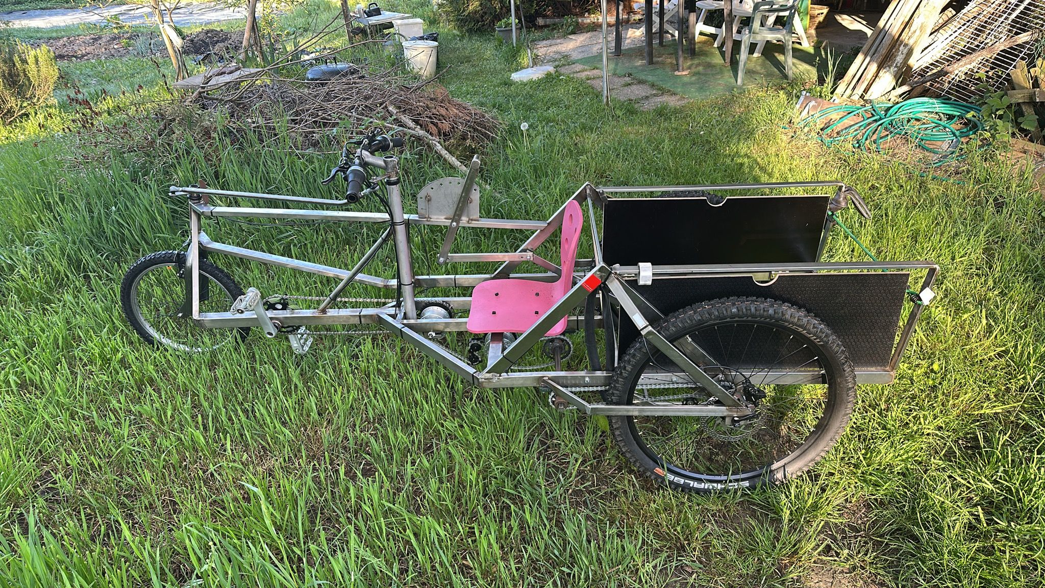 Le prototype du Cyclo-Terre de profil dans une prairie, son porte-charge à l'arrière